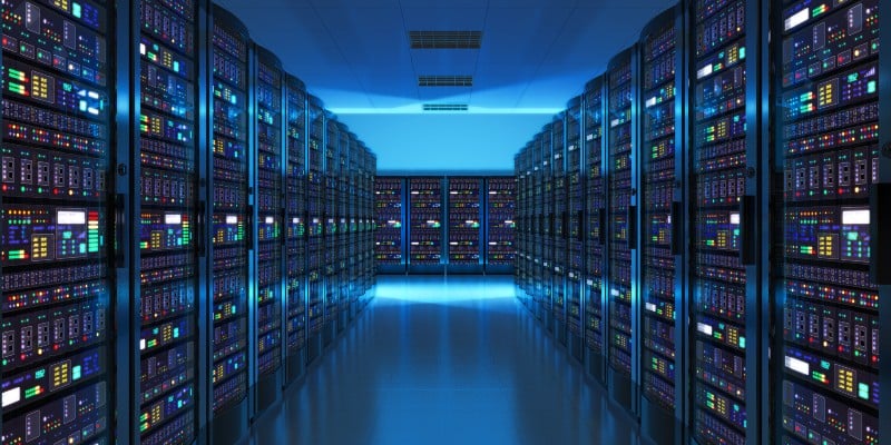 A dimly lit server room featuring rows of high-tech servers with colorful lights and displays, creating a futuristic atmosphere.